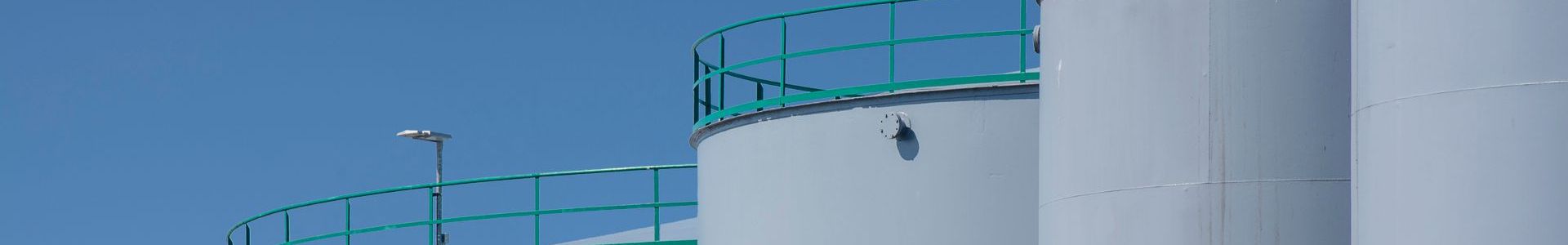 Large industrial storage tanks with green railings